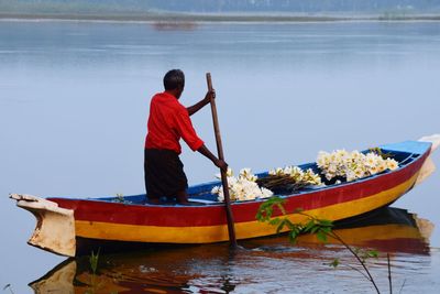 Rear view of man on boat against sea