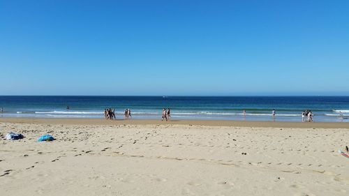 Scenic view of beach against clear blue sky