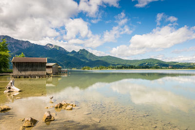 Scenic view of lake by buildings against sky