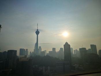 Modern buildings in city against sky during sunset