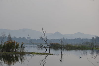 Scenic view of lake by mountains against sky