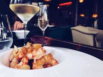 Shrimp food served in plate with wine on table at restaurant