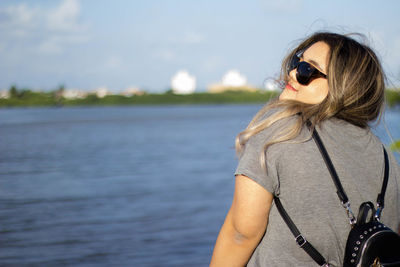 Woman in sunglasses against lake