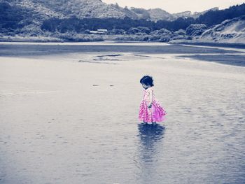 Rear view of woman standing on sea shore