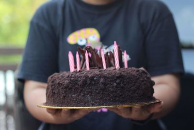 Midsection of person holding cake