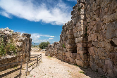 View of stone wall against cloudy sky