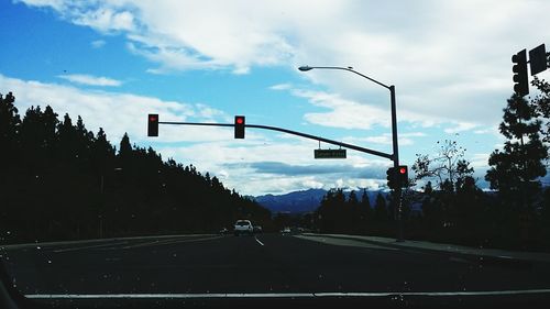 Road by trees against sky