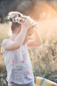 Cute girl wearing flowers during sunny day