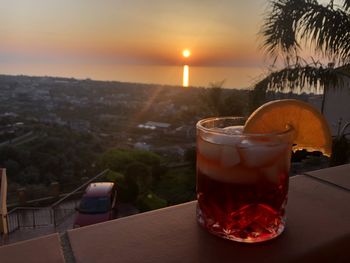 Close-up of drink on table against sky during sunset