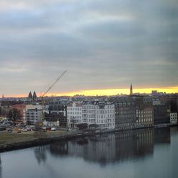 River by cityscape against sky