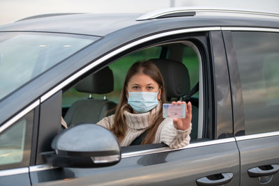 Portrait of woman holding car