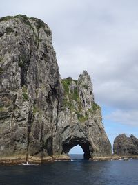 Rock formations by sea against sky