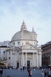 Group of people in front of historic building against sky