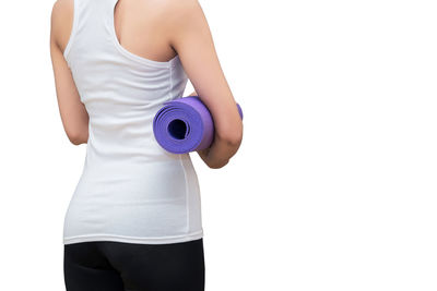 Midsection of woman holding purple while standing against white background