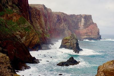 Scenic view of rock formation in sea against sky