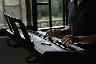 Midsection of man playing piano