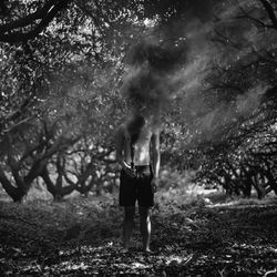 Man holding smoke bomb in forest