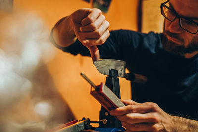 Midsection of man working on cutting board