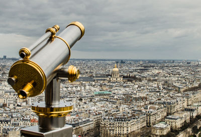 Close-up of coin-operated binoculars against cityscape seen from eiffel tower