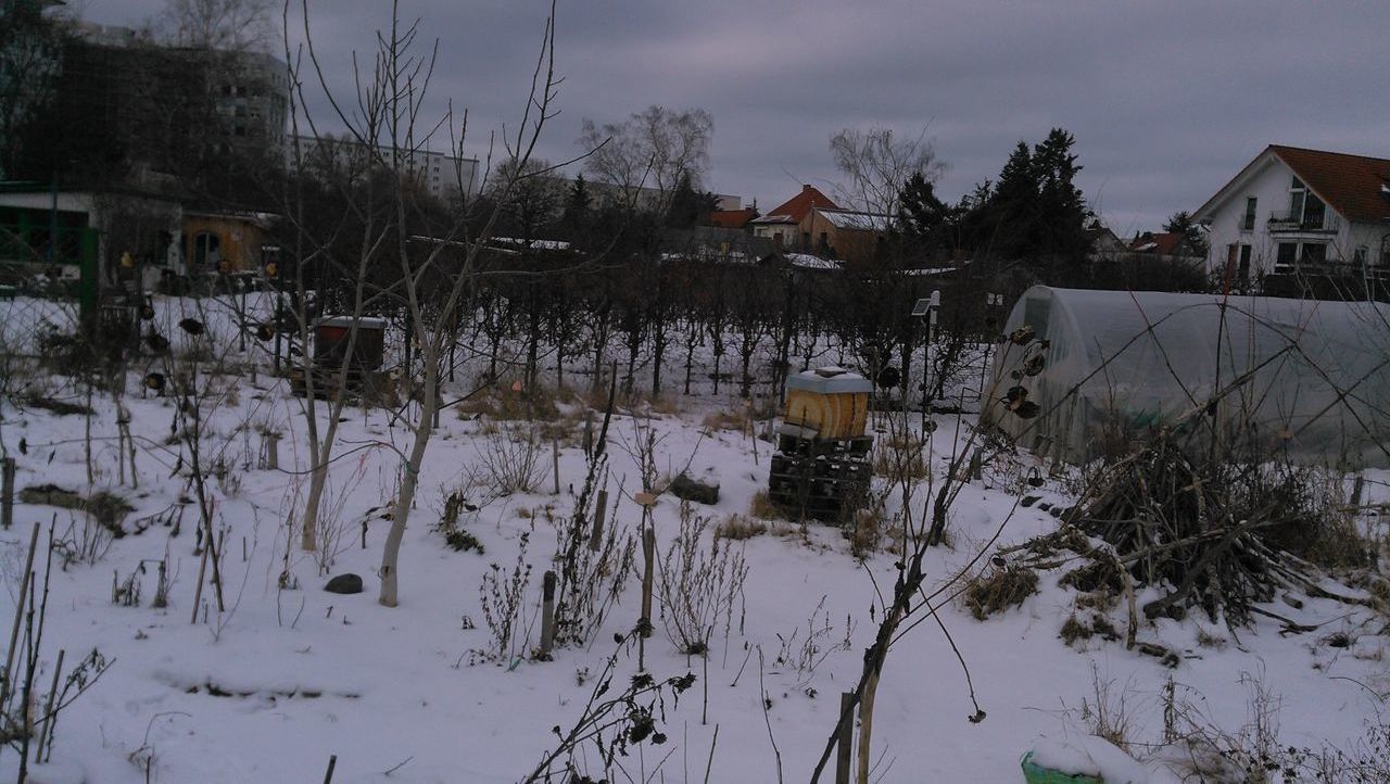 HOUSES ON SNOW COVERED FIELD AGAINST SKY