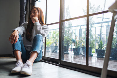 A sad and stressed young asian woman sitting alone in the room