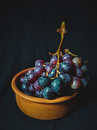 Close-up of grapes on table against black background