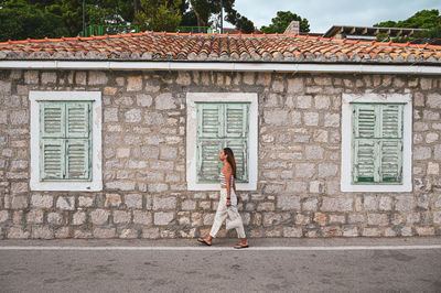 Woman standing by building in ancient ocean town 