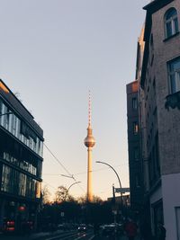 View of communications tower in city against clear sky