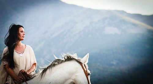 Woman horseback riding during foggy weather