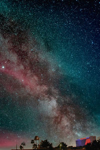 Rear view of man standing against sky at night