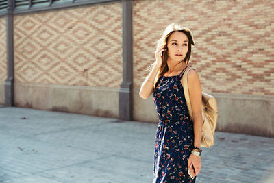 Portrait of young woman standing on street