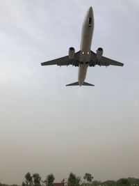 Low angle view of airplane flying against sky