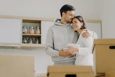 Low angle view of couple embracing while standing at home