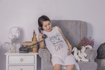 Young woman sitting on sofa at home