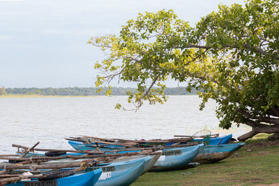 Boats moored in lake against sky