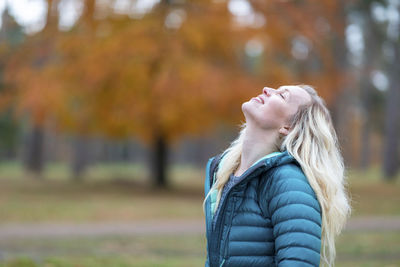 Side view of woman standing against blurred background