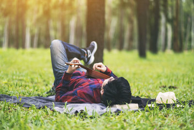 Rear view of man lying on grass in park