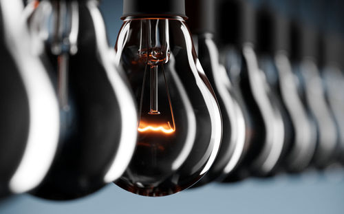 Close-up of light bulb hanging in row