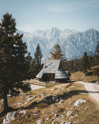 Trees and houses on mountain against sky