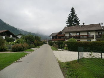 Houses by road amidst buildings against sky