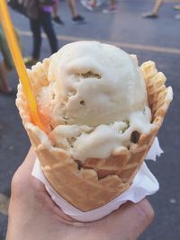 Cropped image of hand holding ice cream on street