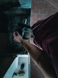 Midsection of man standing by wall in building