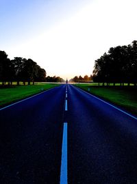 Empty road along trees