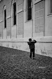 Full length rear view of man walking on street