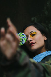 Smiling young woman with candy outdoors