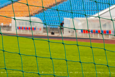 Close-up of soccer field seen through goal post net