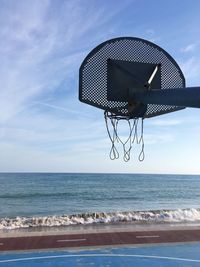 Basketball hoop on sea against sky