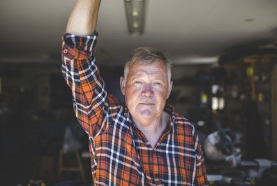 Portrait of confident senior man standing in workshop