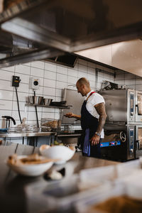 Side view of man preparing food in kitchen