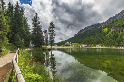 Scenic view of lake by trees against sky